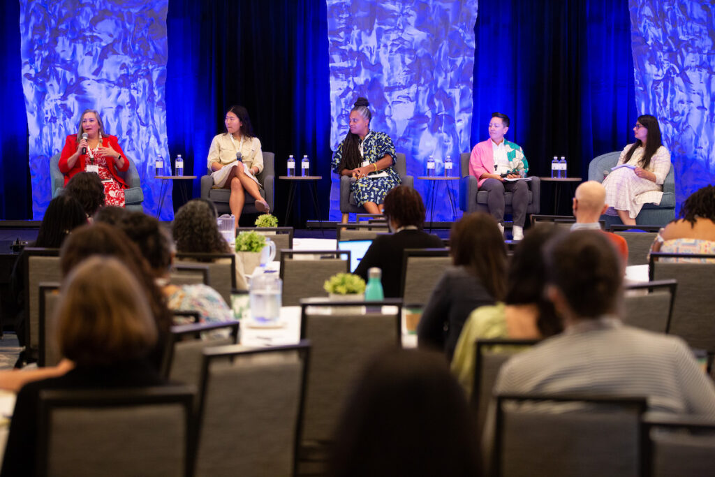 Crystal Middlestadt, Eileen Briggs, Kaberi Banerjee Murthy, Melody Baker, and Yichen Feng are on stage speaking for the plenary session entitled "Connecting to Local Communities - A Spectrum of Participatory Practices in Grantmaking."